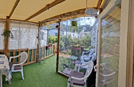 Véranda couverte avec fauteuils côté jardin
